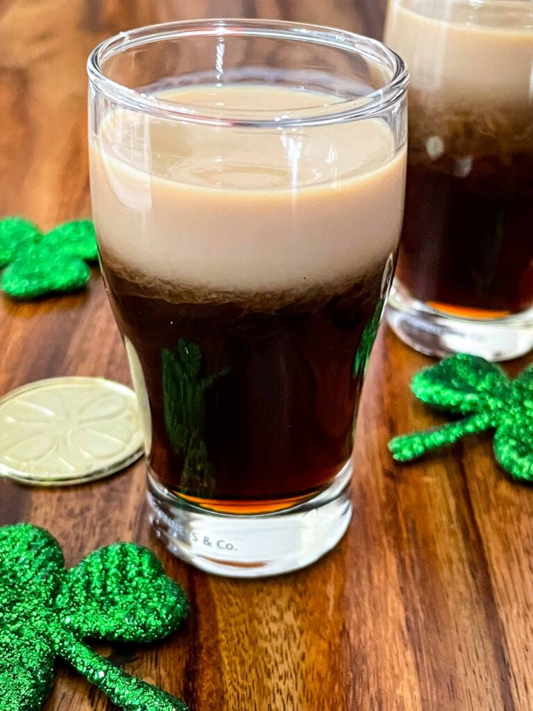 Baby Guinness Shot in pint shaped shot glass with gold coins and shamrocks.