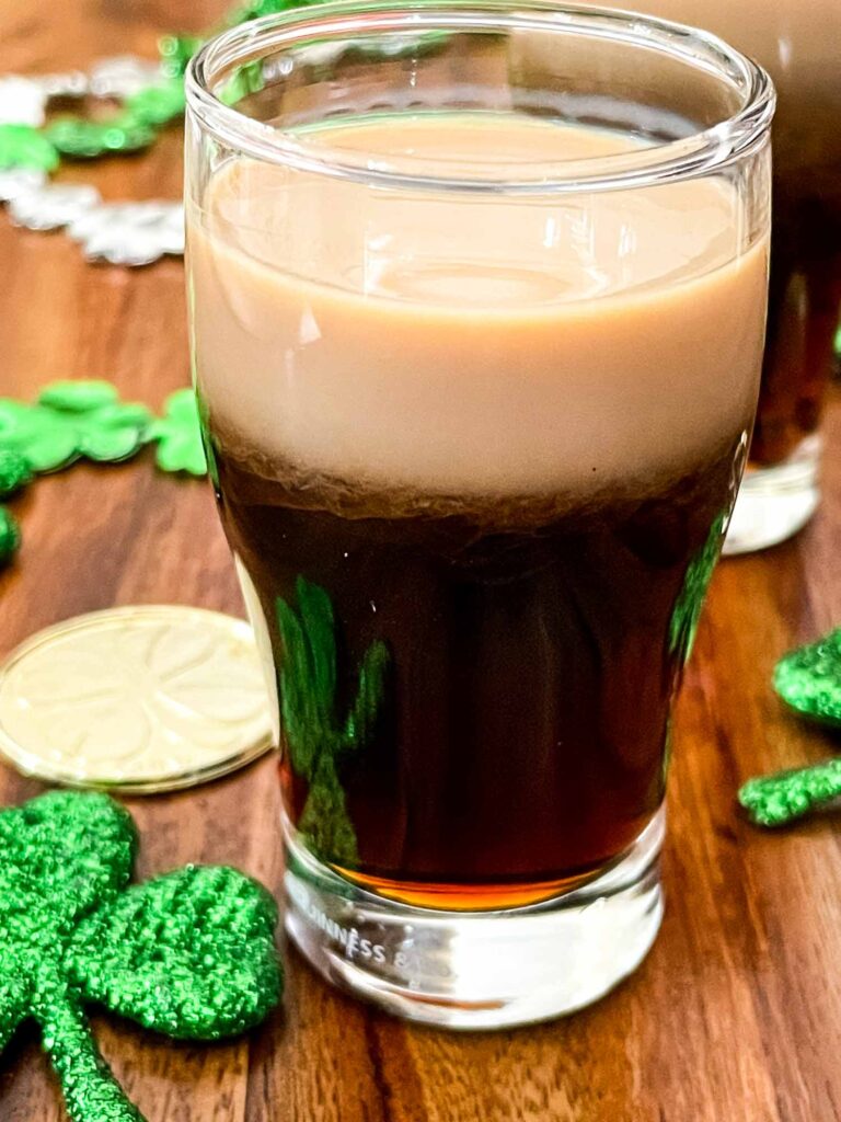 Baby Guinness Shot in pint shaped shot glass with gold coins and shamrocks.