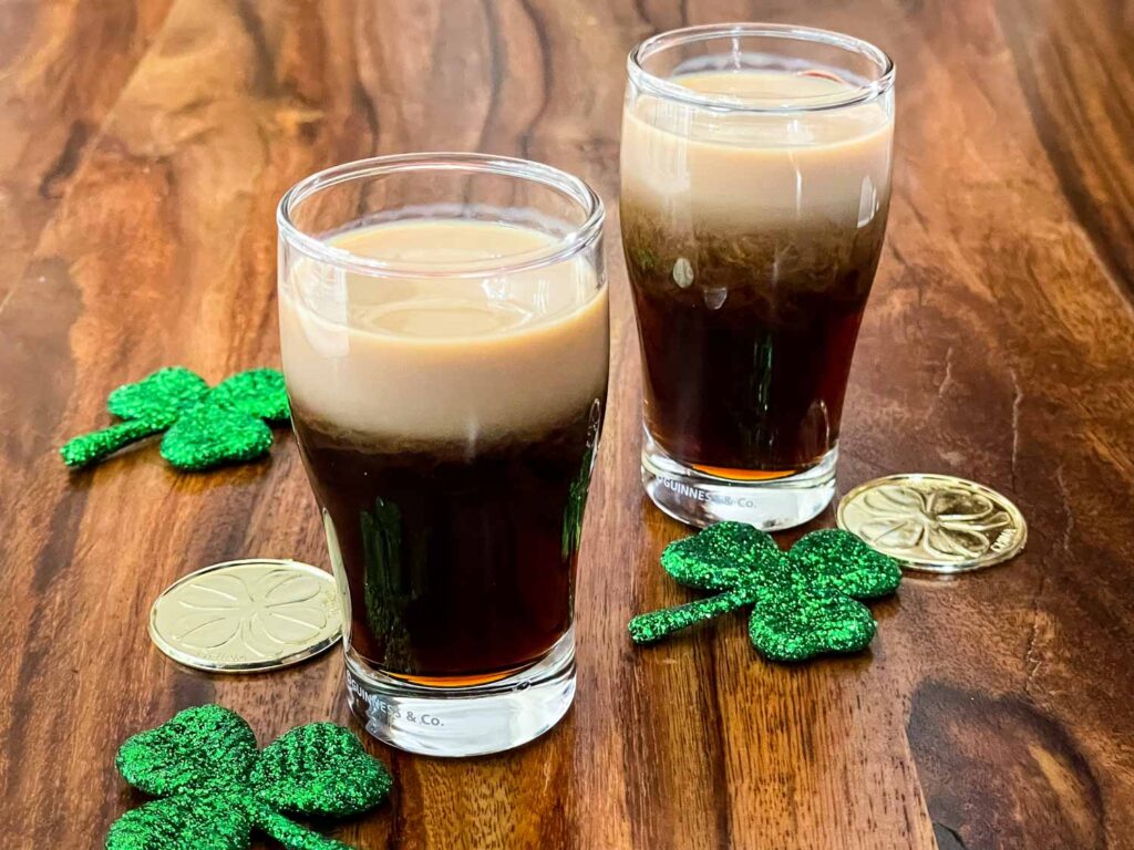 2 Baby Guinness Shots in pint shaped shot glasses with gold coins and shamrocks.