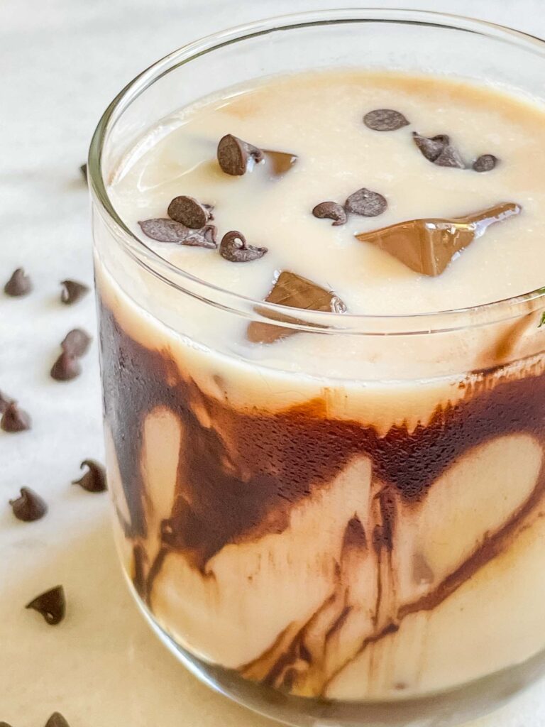 Closer view of a Snickers Vodka Cocktail in a clear glass with chocolate drizzle
