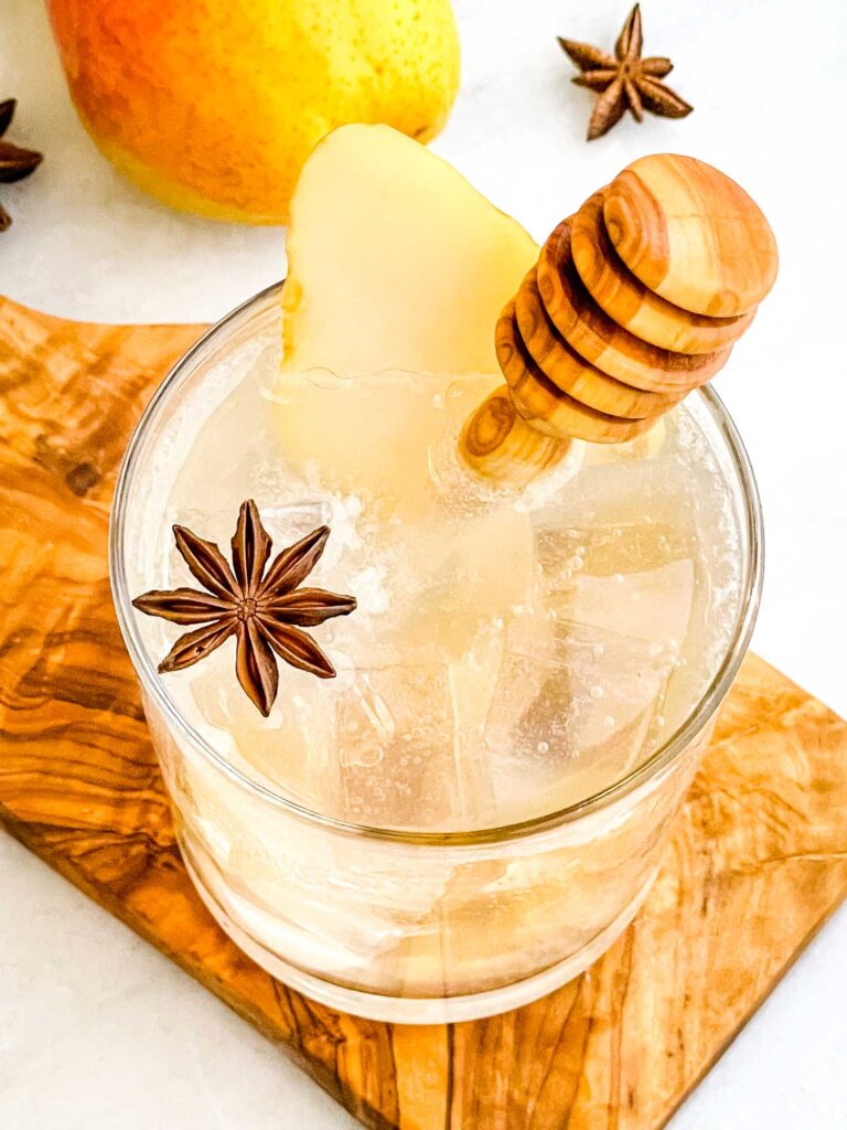 Top view of a vodka Honey Pear Collins in a glass sitting on a wood board