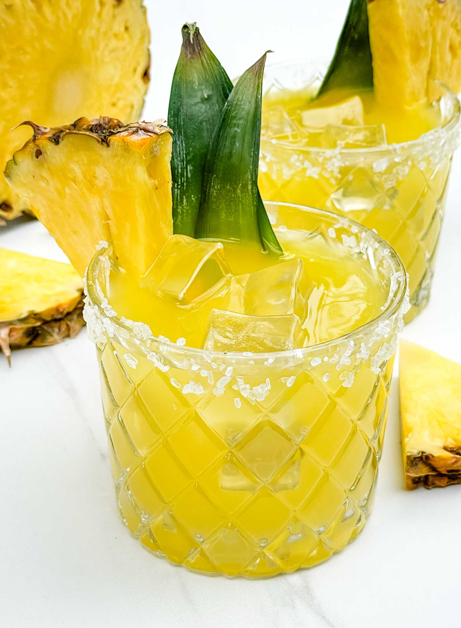 A glass of Pineapple Margarita with a pineapple wedge garnish.